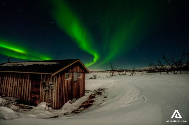 Northern lights above hut Northern lights above wooden hut in Sweden