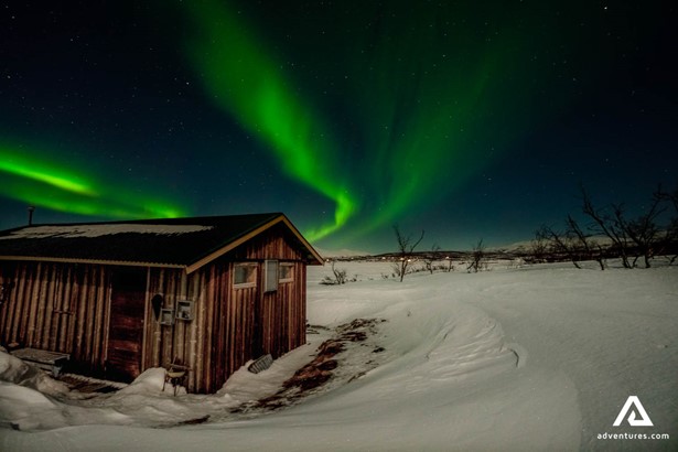 Aurora Borealis above the wooden cabin
