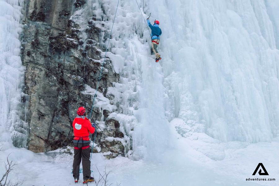 guide helping to ice climb