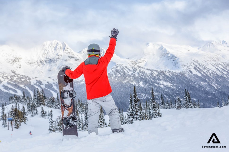 happy man snowboarding in Canada