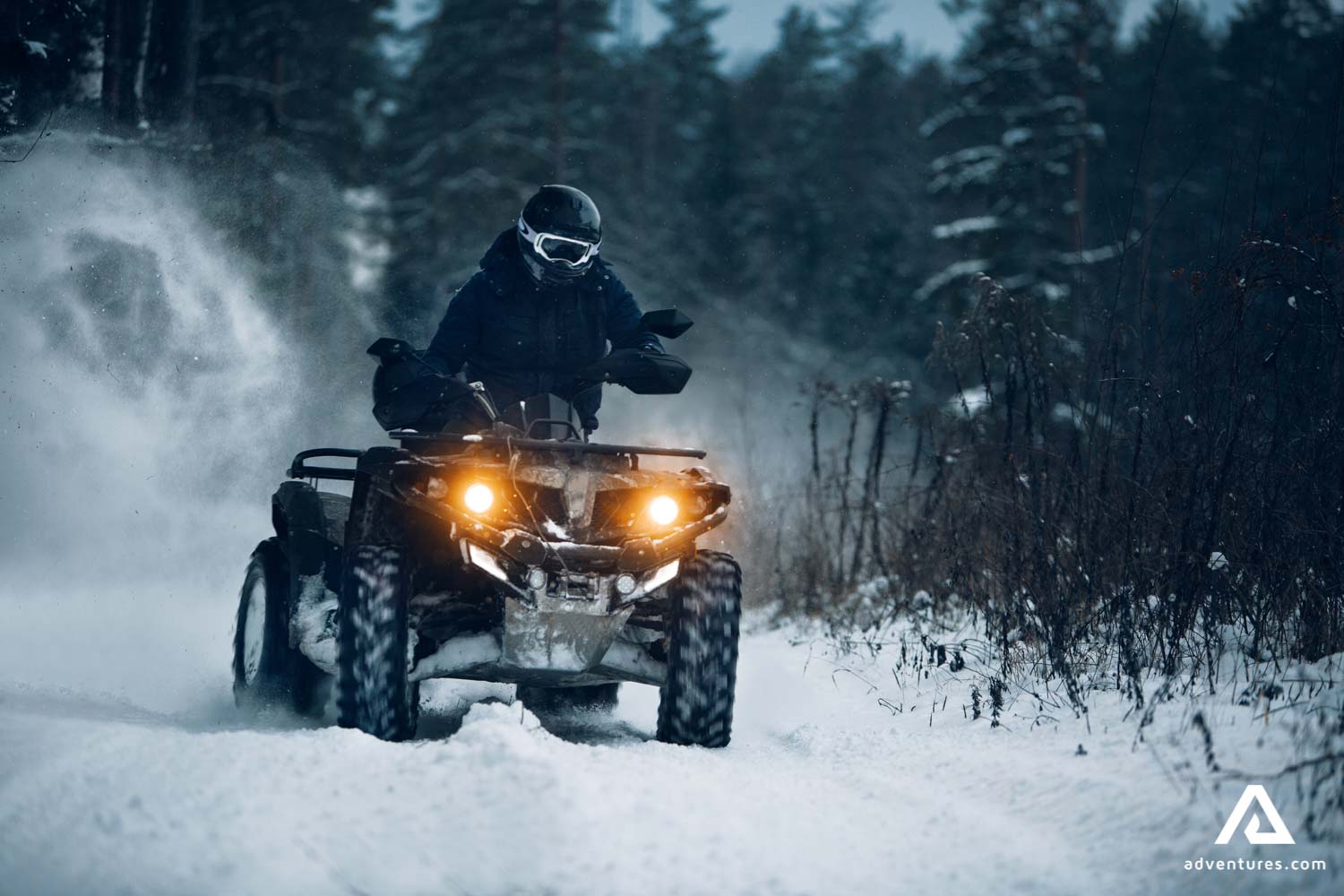 man quad biking on winter in Finland