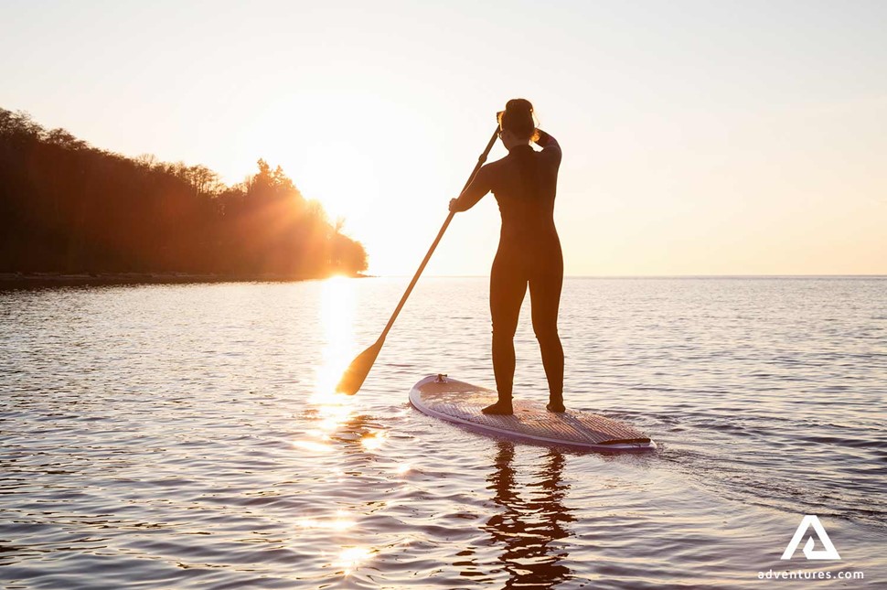 Woman paddling in Canada at sunset