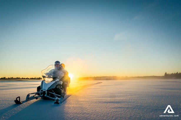 snowmobiling tour by the sunset during winter
