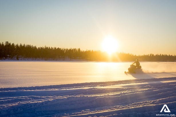 Riding snowmobile in Laplandic snowy field