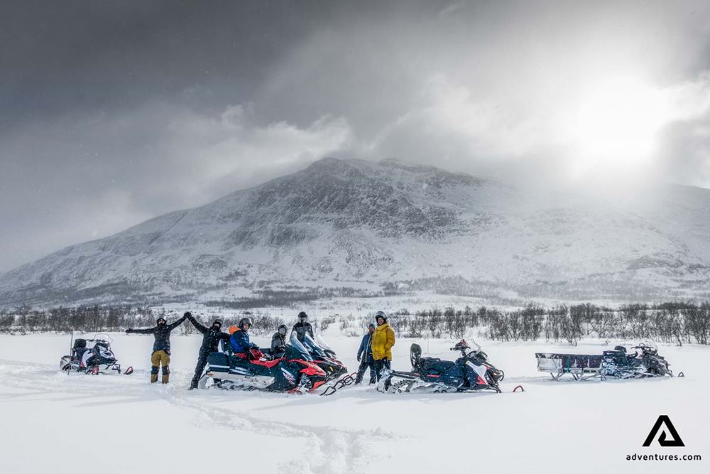 excited group of people snowmobiling