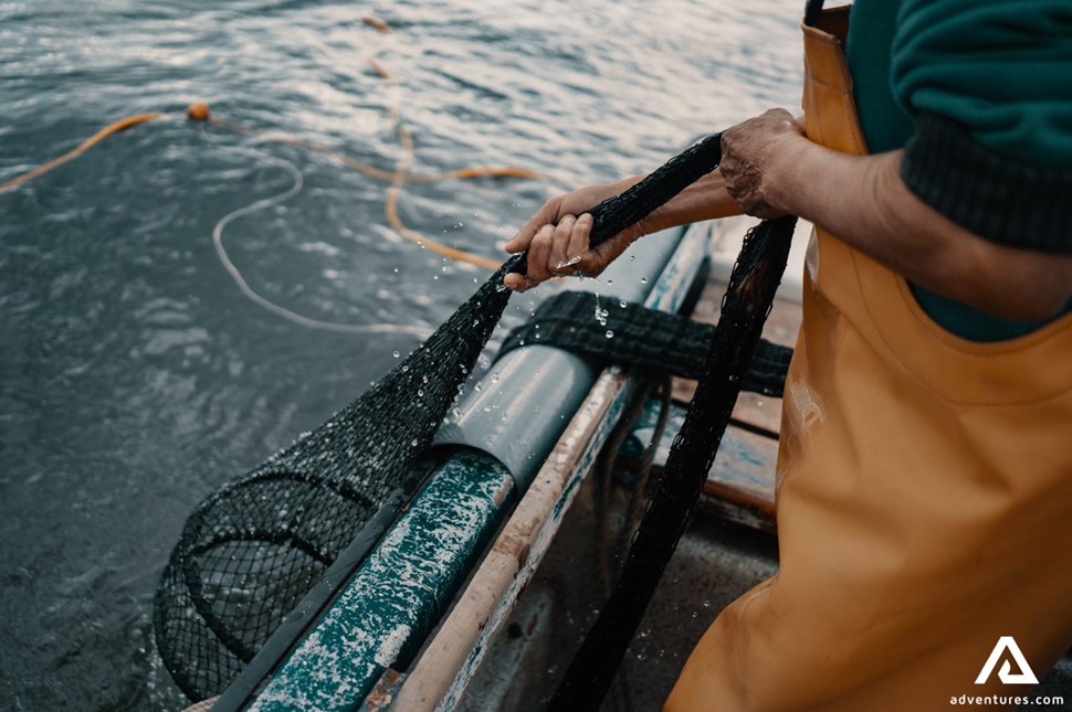 Fisherman catching the fish from boat