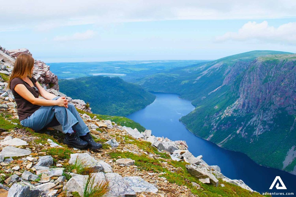 woman sitting on mountain summit in Gros Morne park