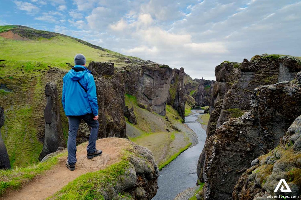 man standing on cliff of Fjadrargljufur canyon in Iceland