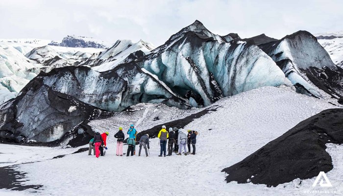 Group standing by glacier crevasses in Iceland