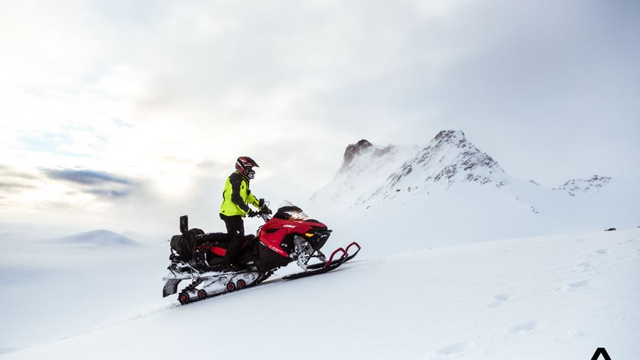 Man Snowmobiling up the Glacier