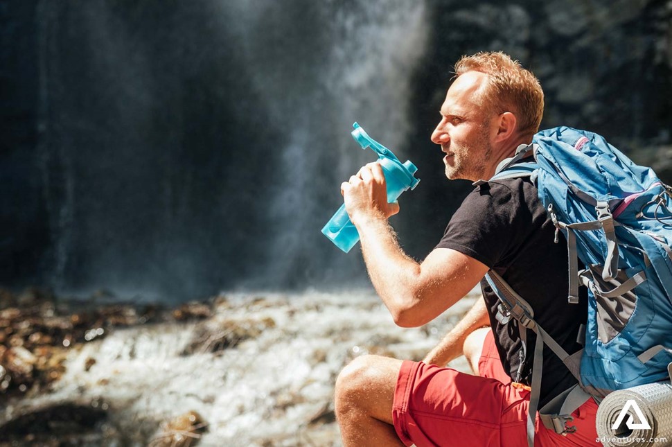 Man with Hiking Equipment Drinking Water