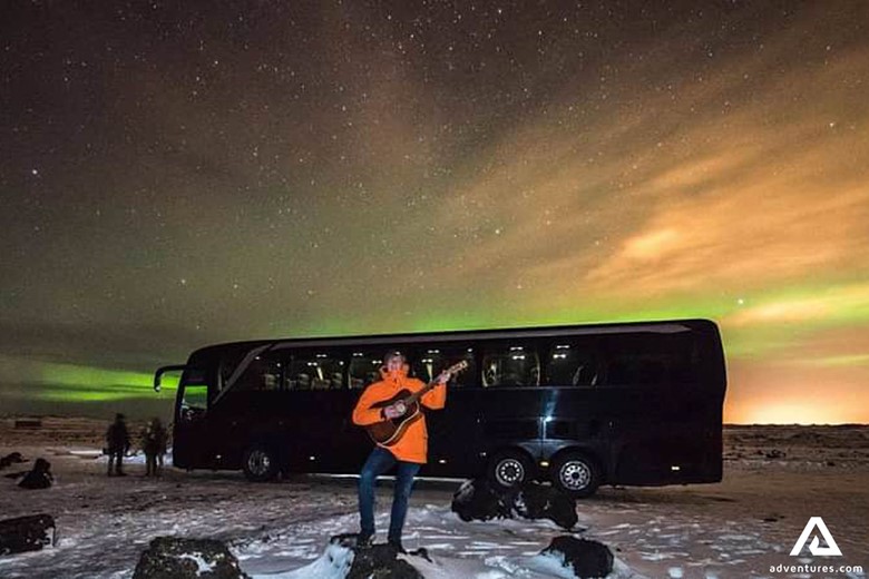 Man Playing a Guitar by Bus in Iceland