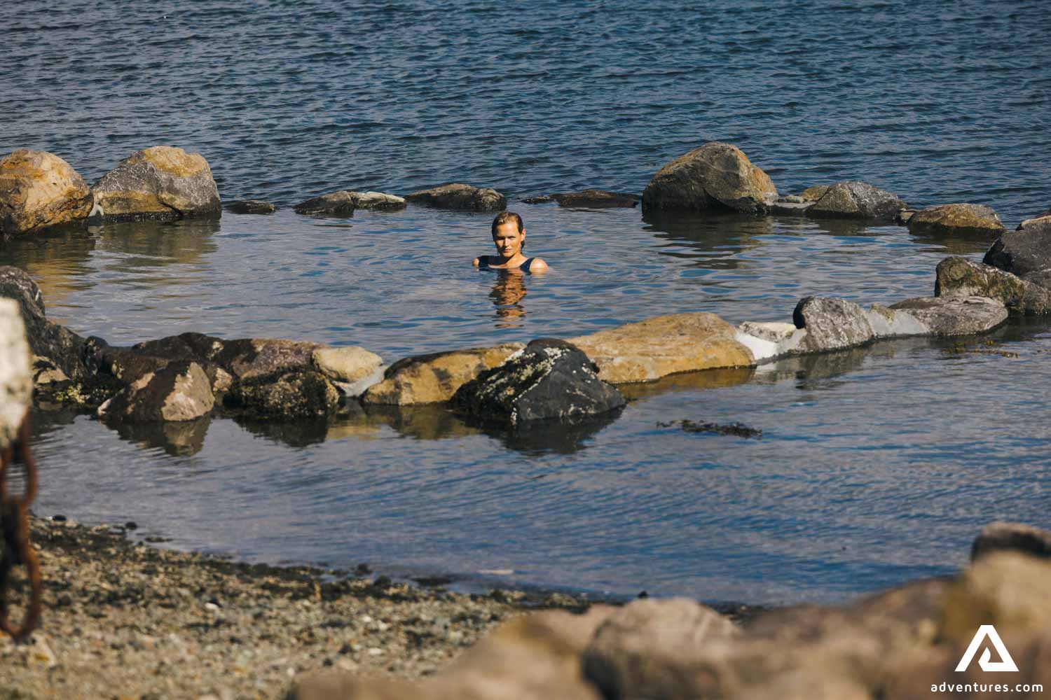Bather soaking in the Hvammsvík Hot Springs