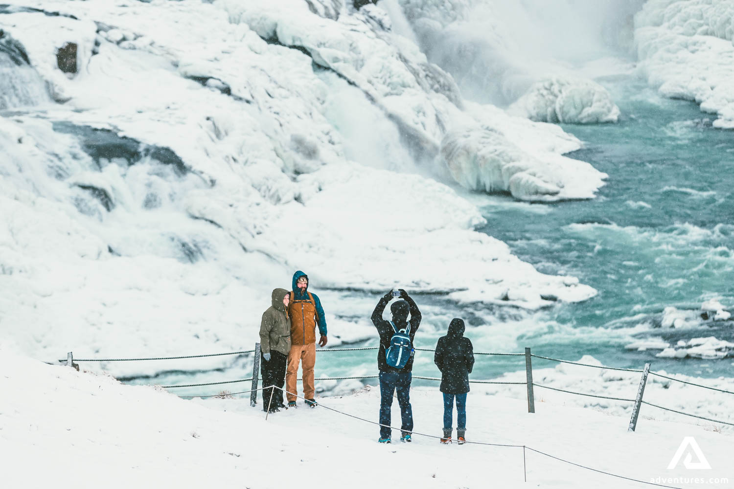 People Taking Photos by Waterfall in Winter