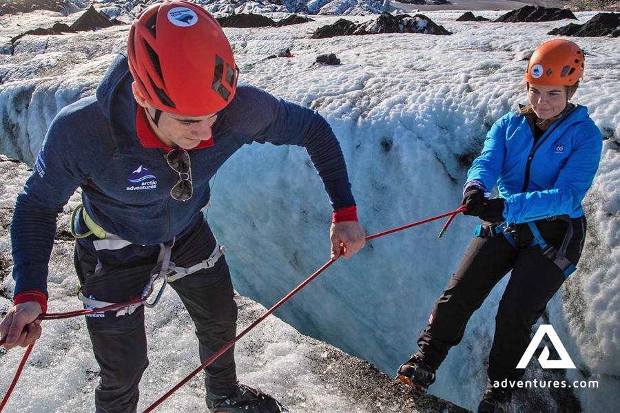 Guide Helping for Woman on Glacier