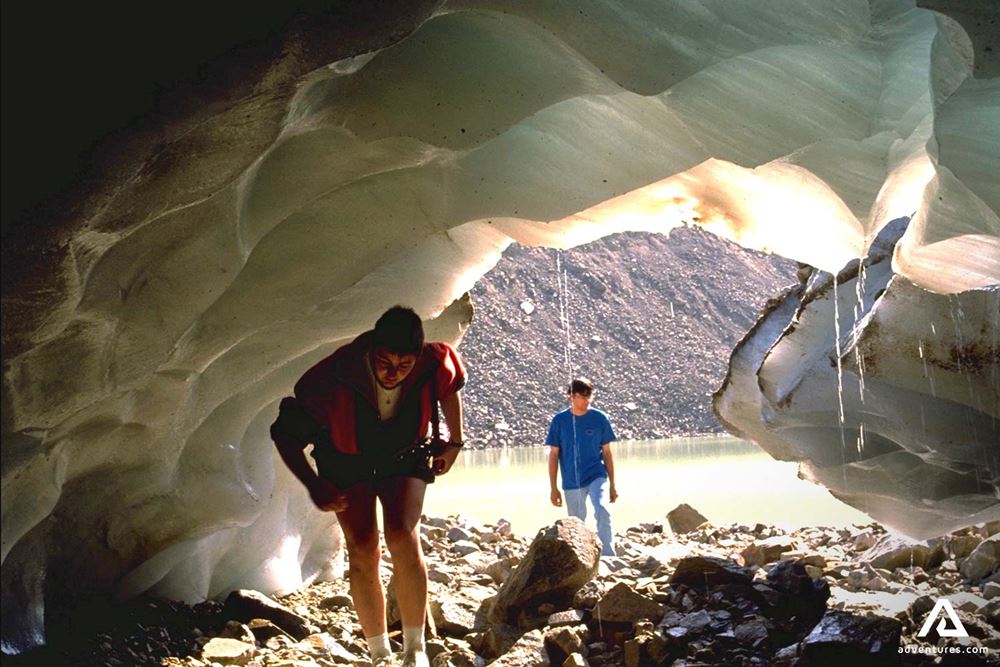 People Exploring Ice Cave in Rocky Mountains