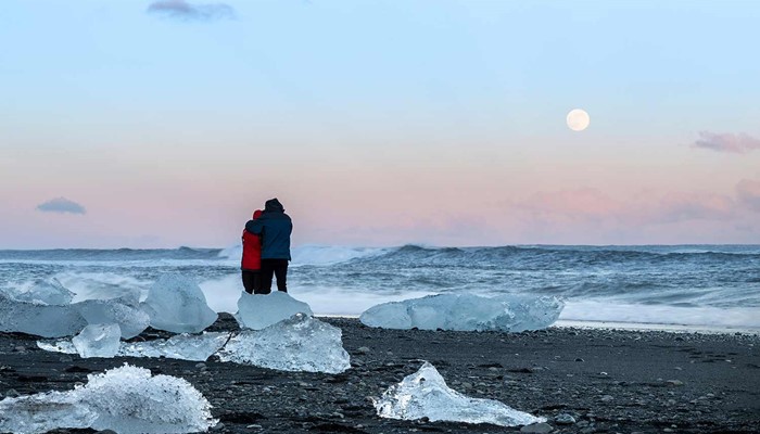 Couple in Icelandic Beach With Icebergs