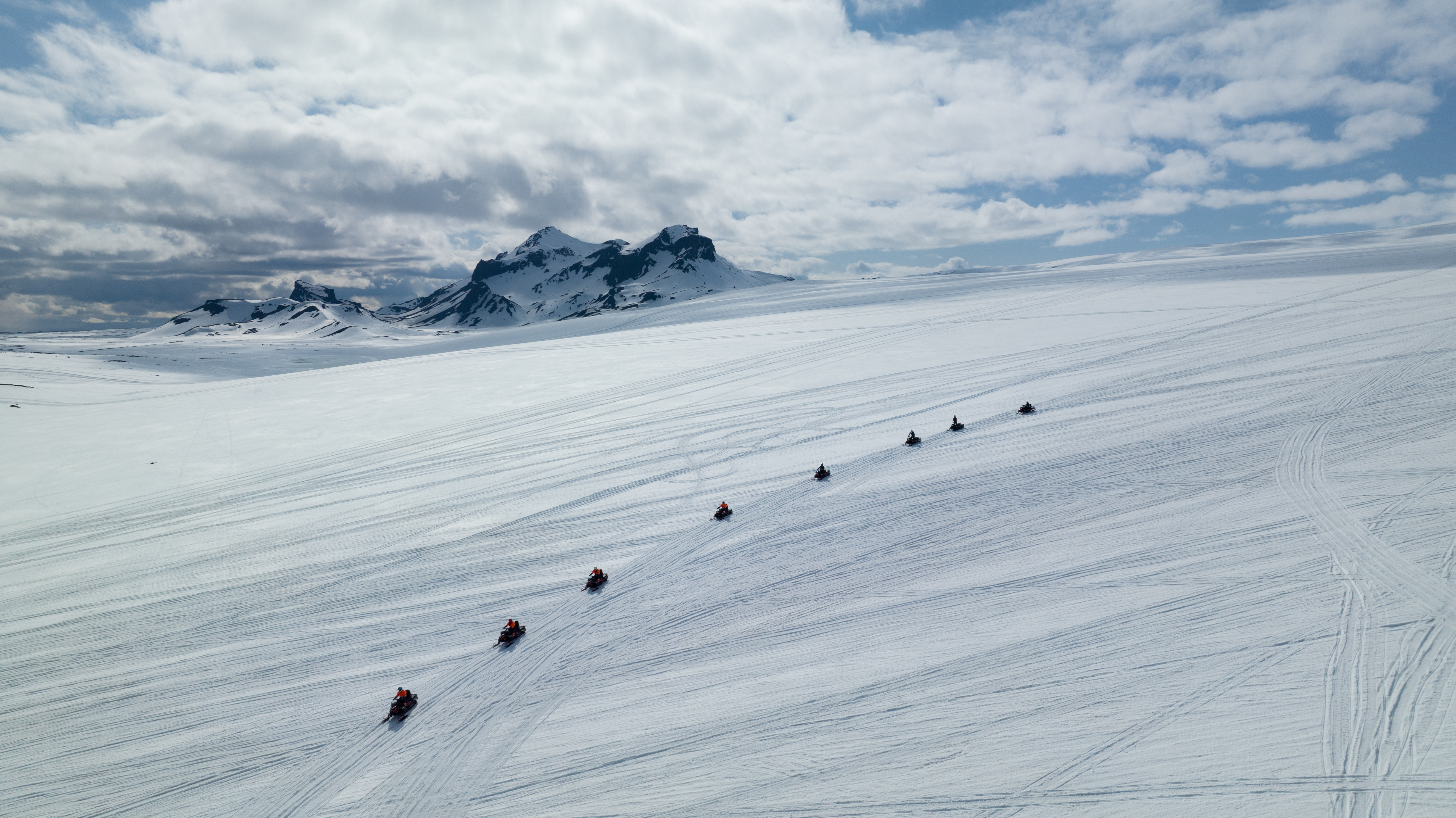 Group Riding Snowmobiles on Glacier