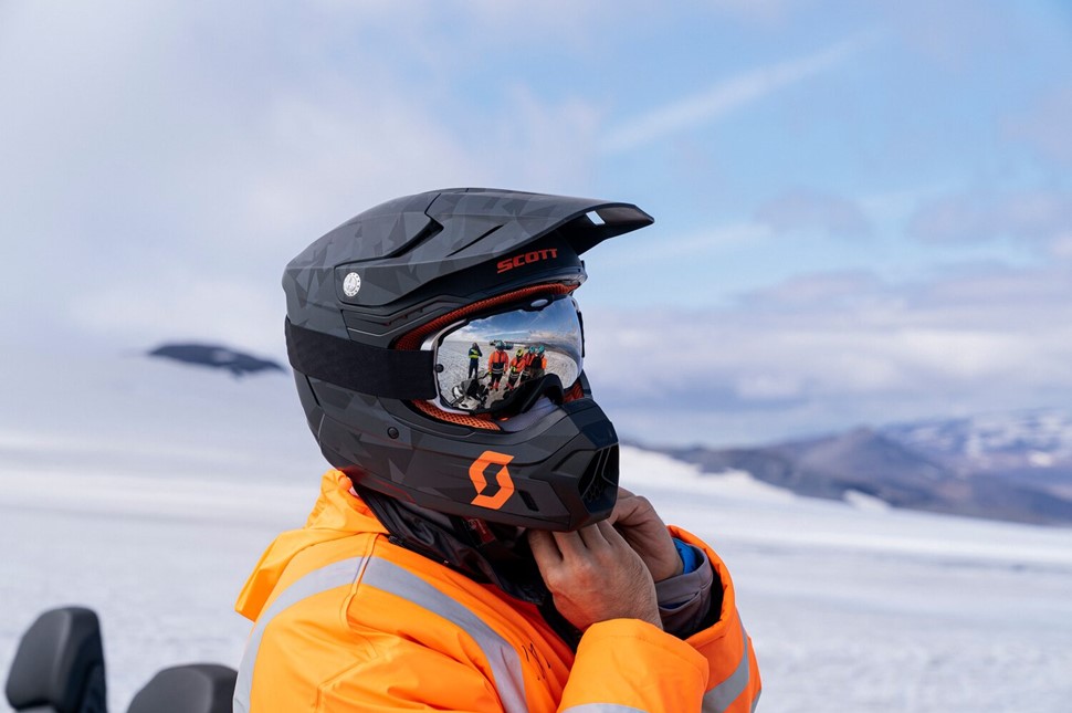 Person putting on gear for snowmobiling
