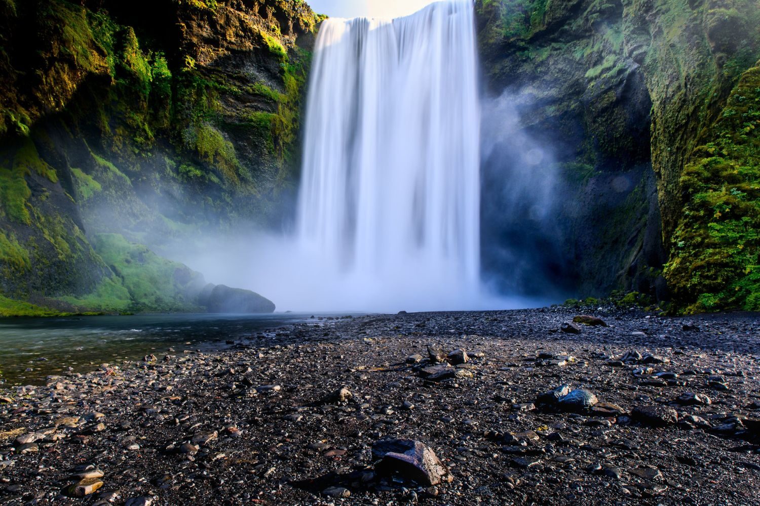 Skogafoss Waterfalls in Iceland against a rocky foreground