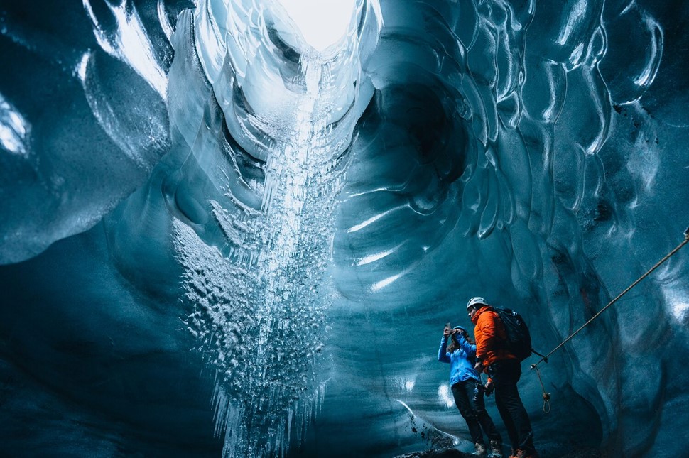 Couple standing at bottom of ice cave