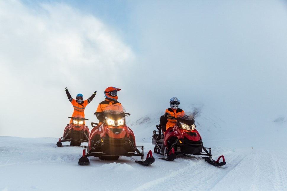 People on snowmobiles on snow surface