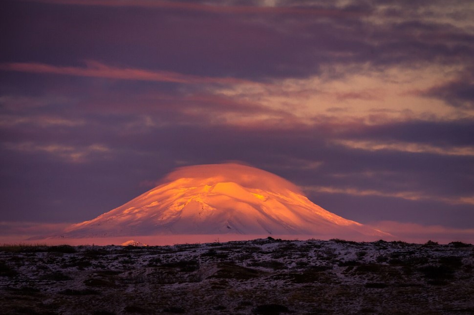 Clouded Hekla glowing orange in sunset