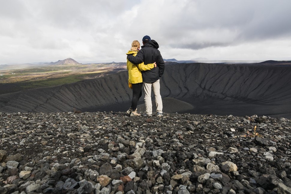 Couple looking into black crater floor 