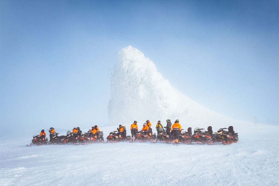 Group of snowmobilers by the top of glacier
