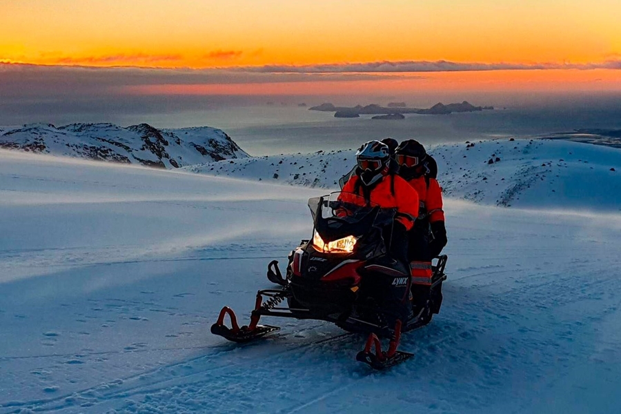 Snowmobiling on a glacier in evening