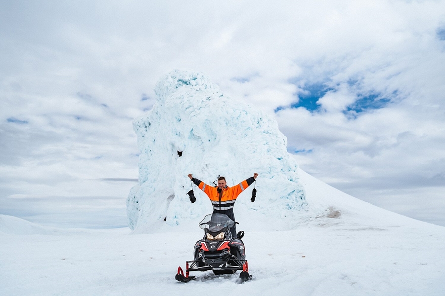 Man with snowmobile by the glacier top