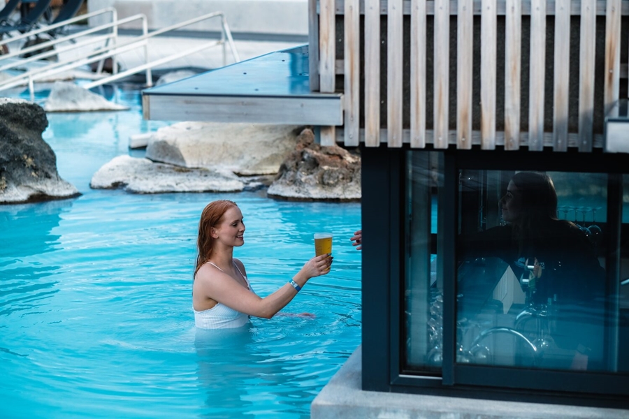 Woman taking beer from bar in Myvatn baths