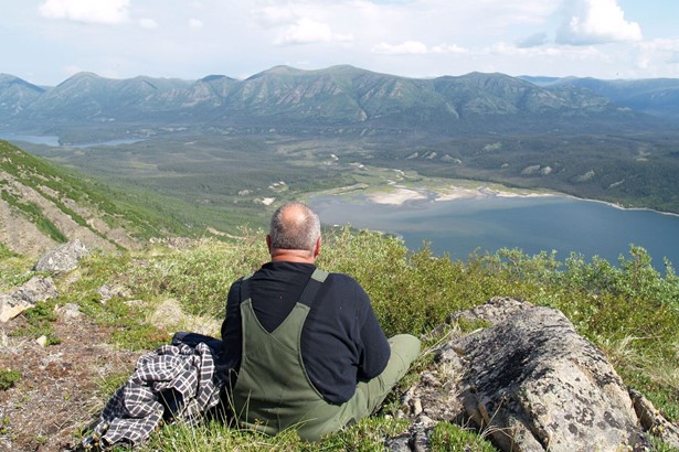 Man looking at Kluane lake from top of the mountain