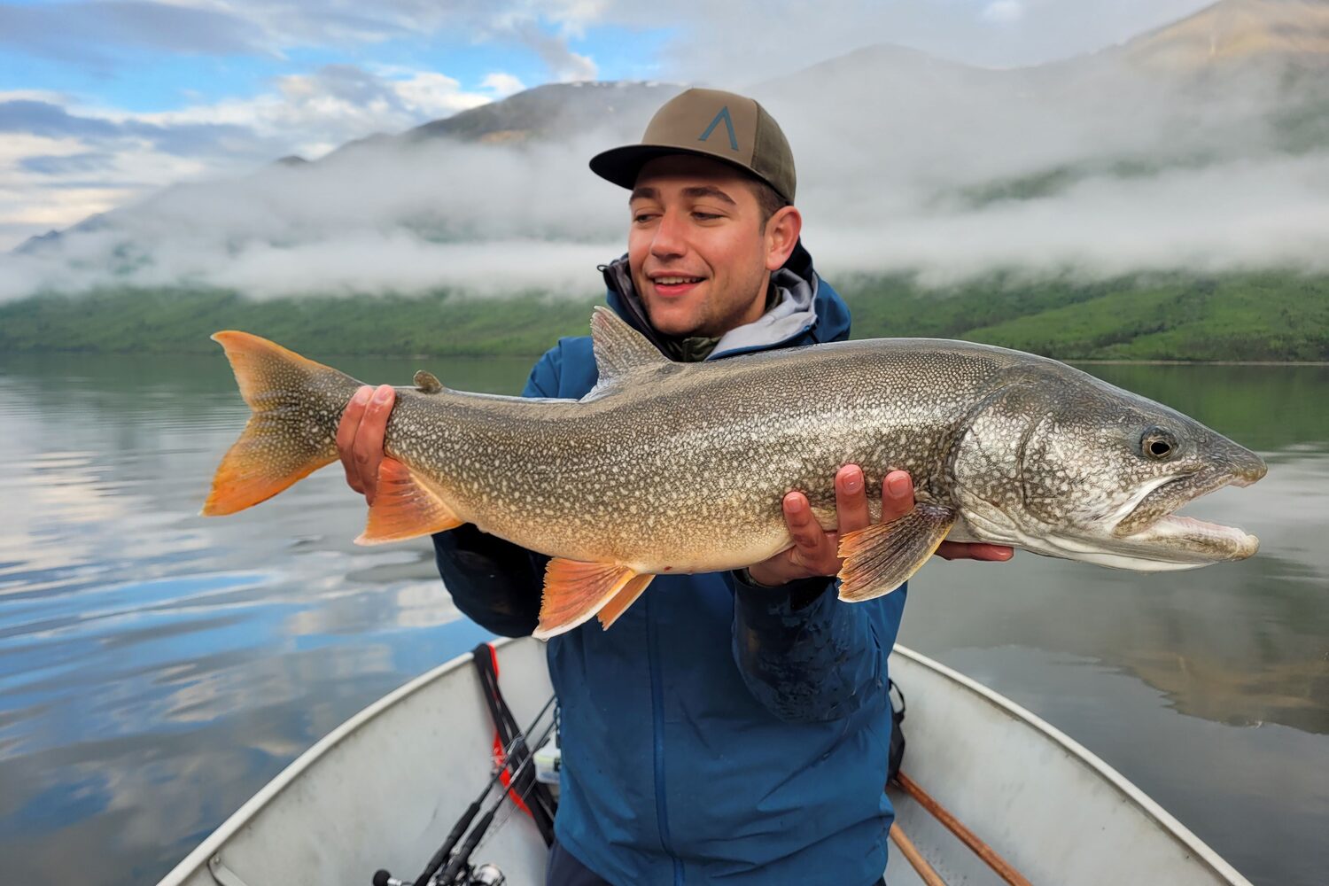 Man with blue jacket holding big fish
