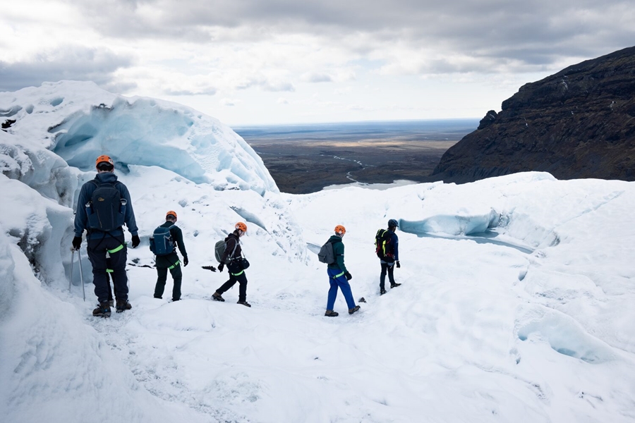 People walking between glacier crevasses