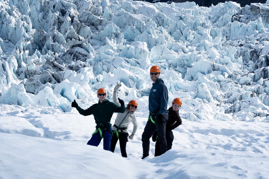Group of people joking on glacier