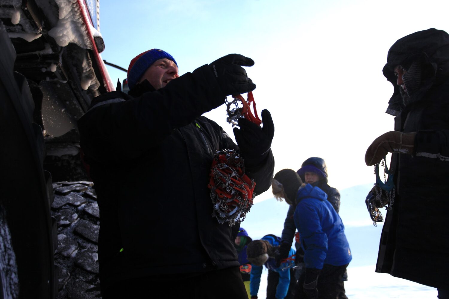 Group of people puts on crampons