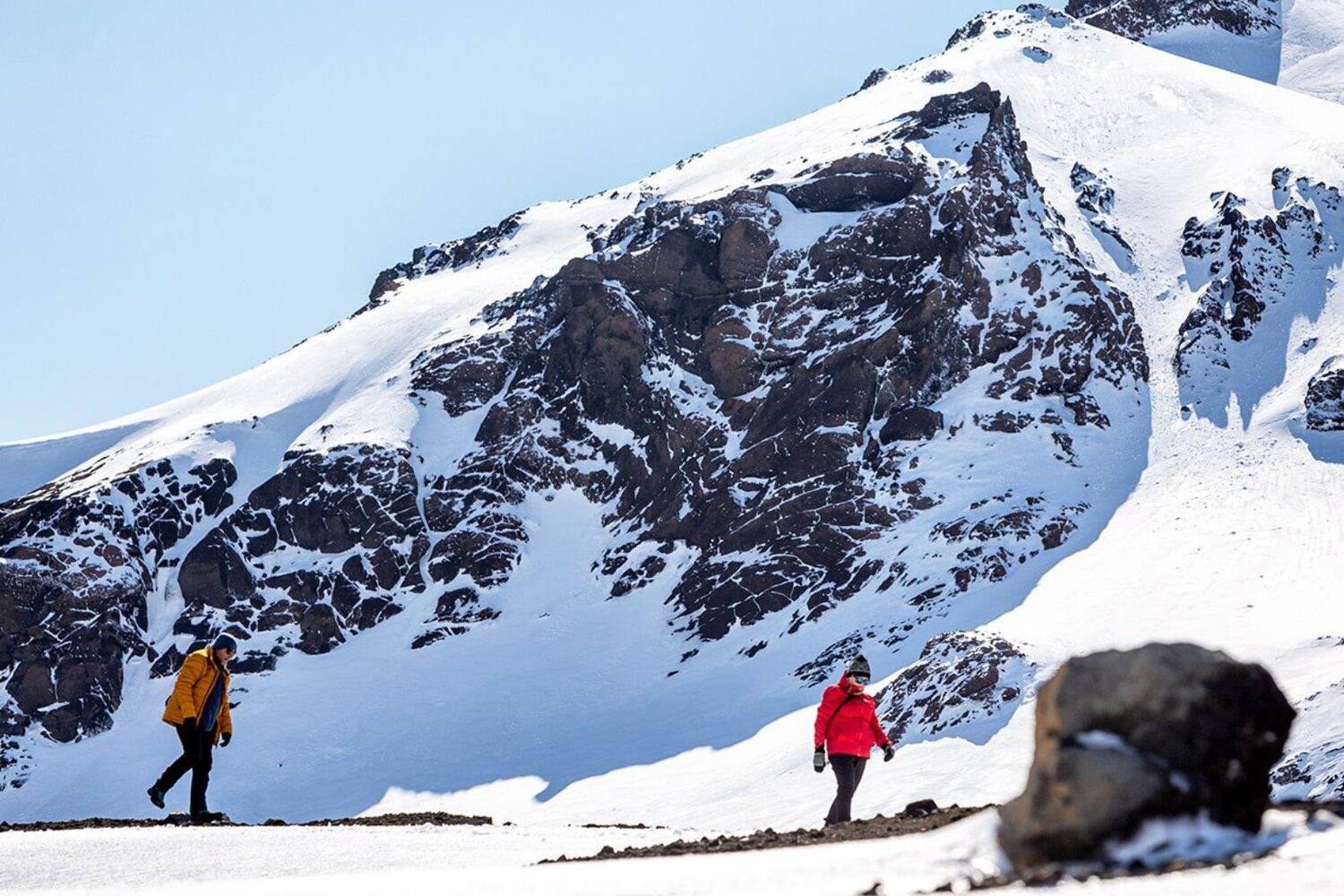 Couple walking by snowy mountains