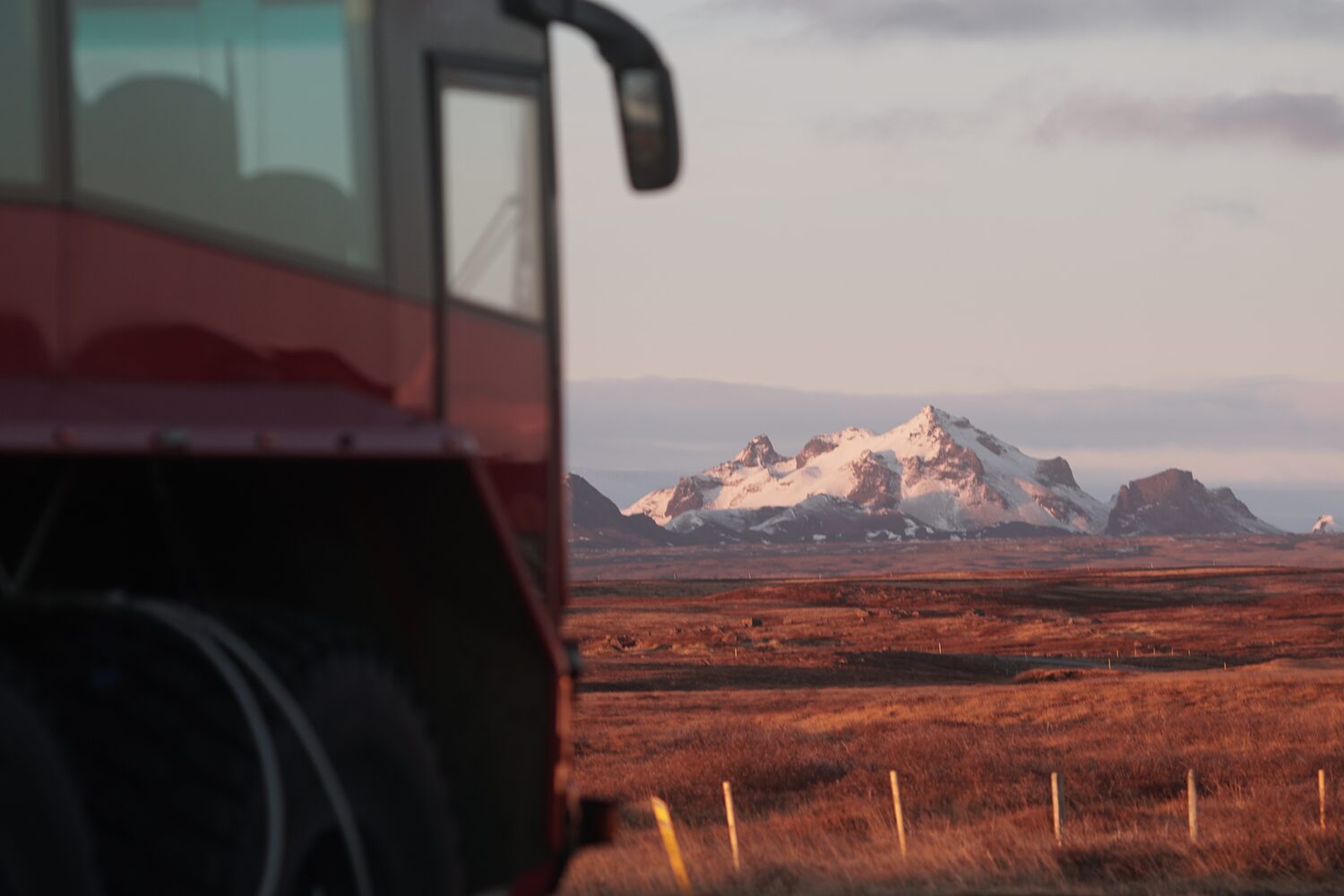 Red truck drives in Icelandic landscape