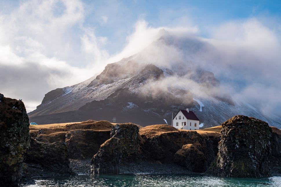 Iceland winter Arnarstapi village Iceland landscape of white house infront of mountain in winter at Arnarstapi village
