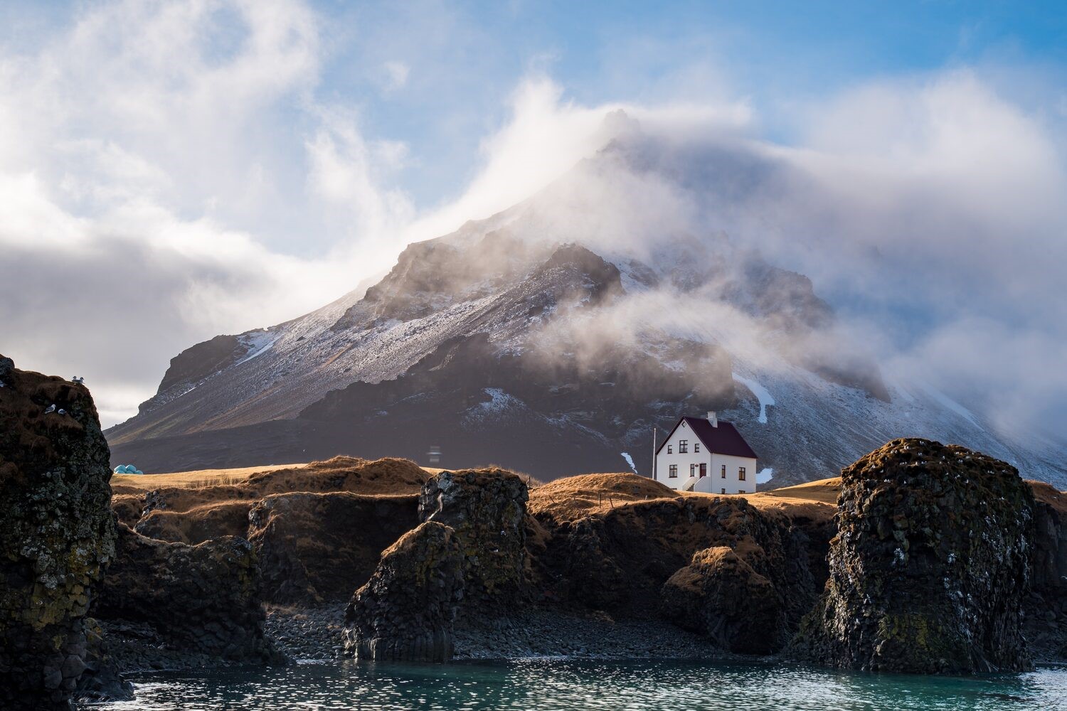 Iceland landscape of white house infront of mountain in winter at Arnarstapi village