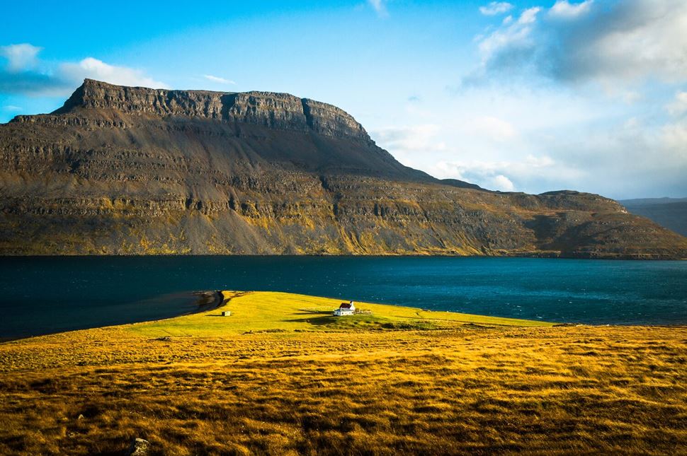 Westfjords ICeland Westfjords Iceland House in the distance mountain surrounded by sea