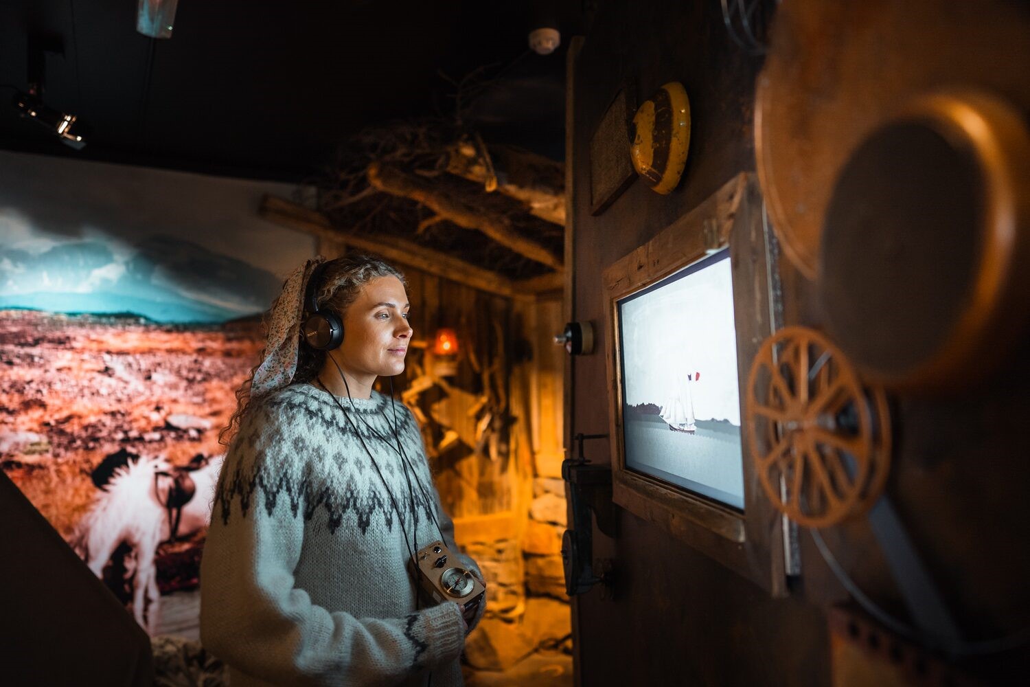 Female tourist at Wilderness center museum Iceland with headphones at audio tour 