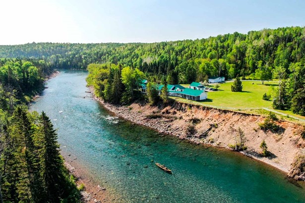 Salmon Bonaventure fishing lodge in Quebec Canada, large river surrounded by forest of evergreen trees