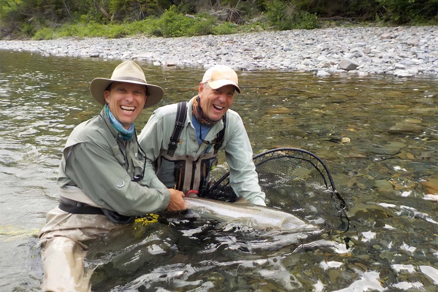 Two happy men showing salmon caught in Bonaventure River