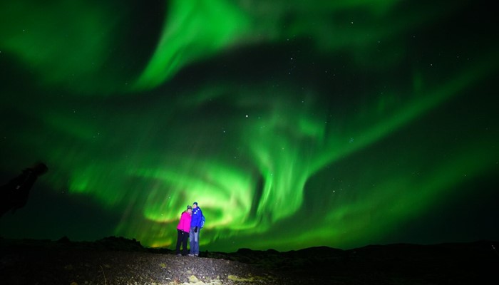 Couple watching beautiful Aurora in Iceland