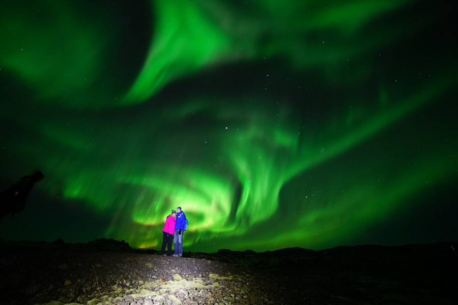 Couple watching beautiful Aurora in Iceland