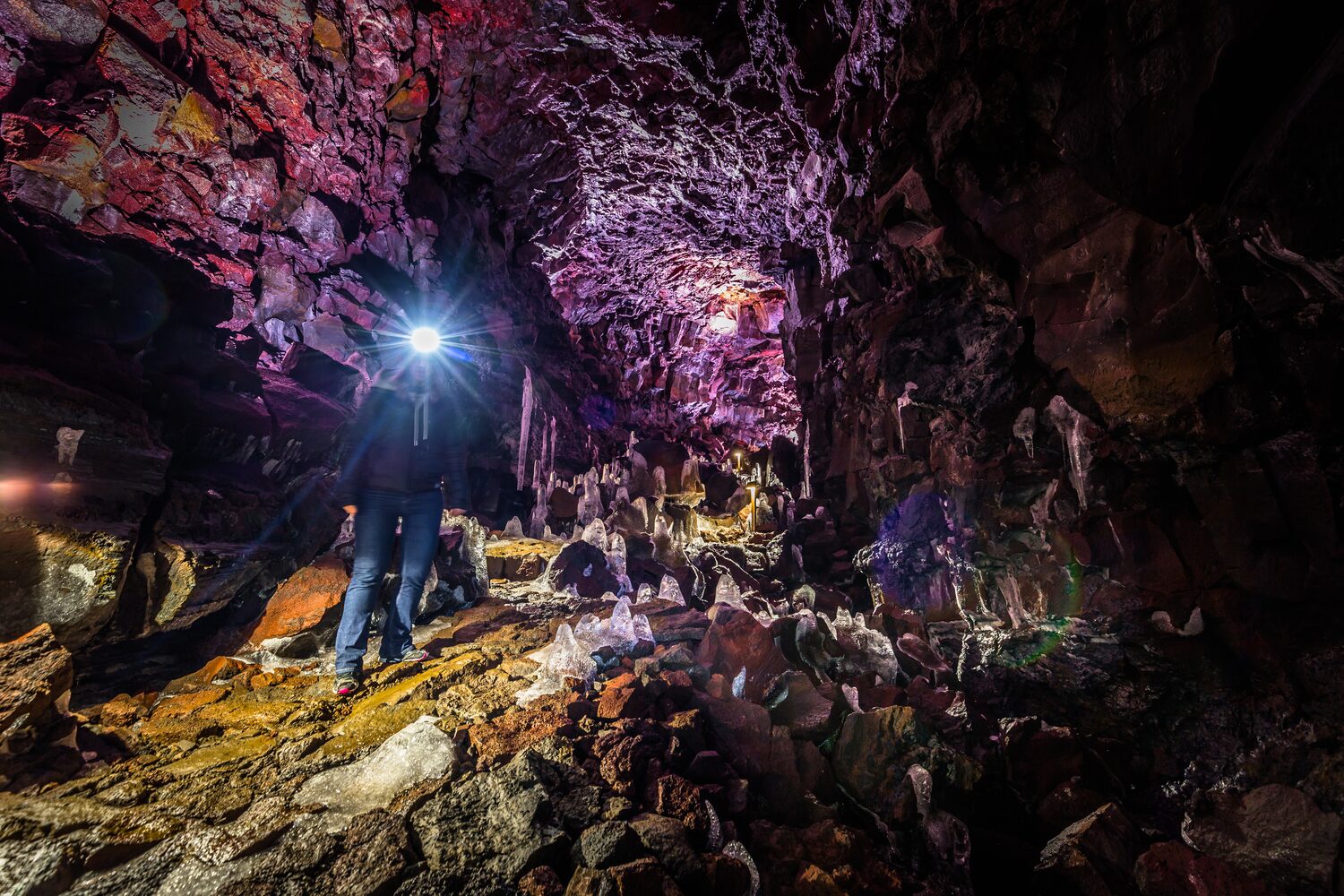 Man standing inside of lava cave in Iceland