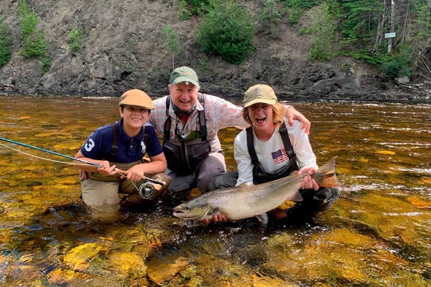 Father with two son caught salmon in Canadian river