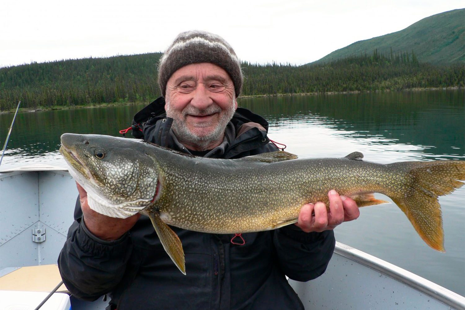Man sitting in boat and showing big fish